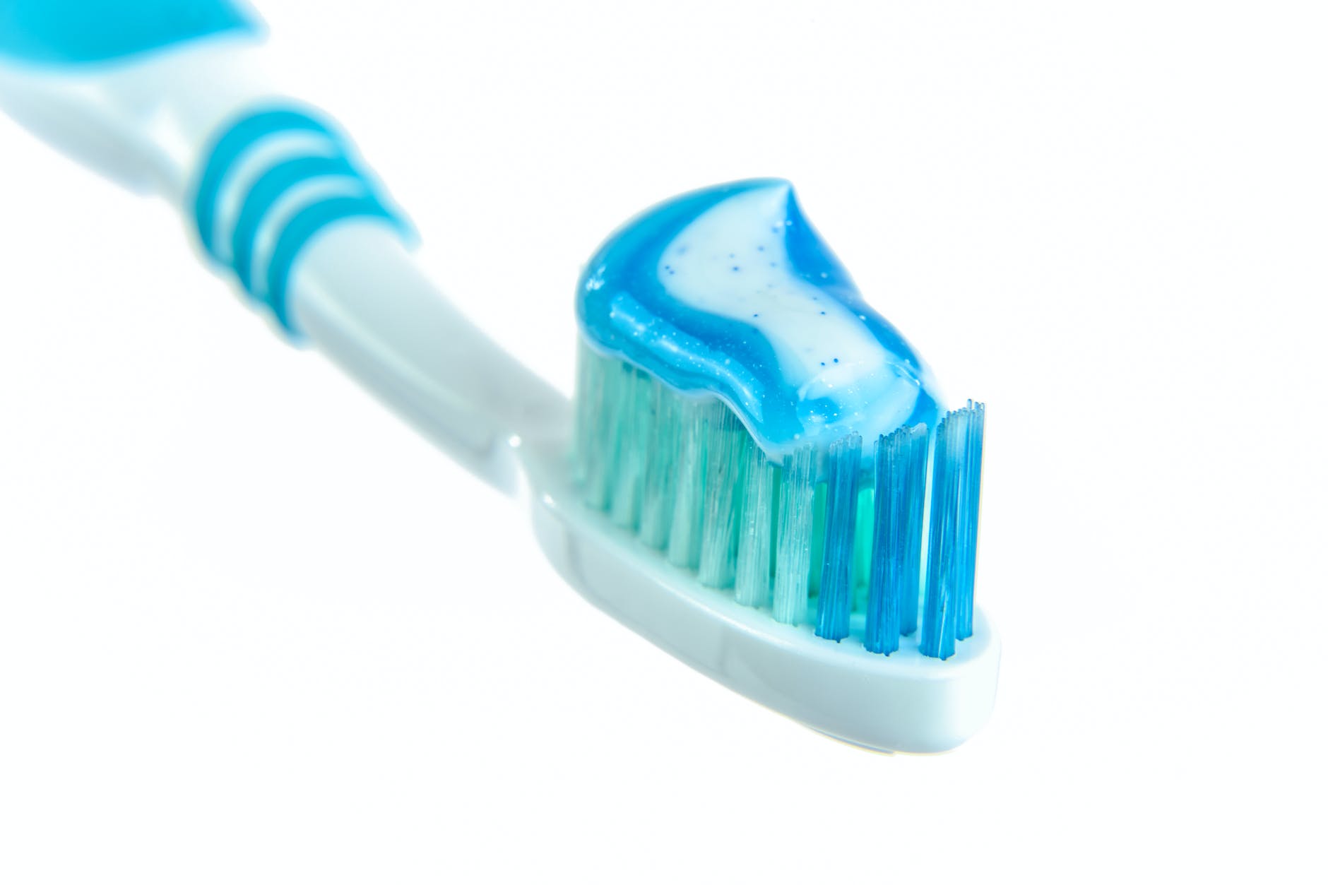 blue and white toothpaste on toothbrush