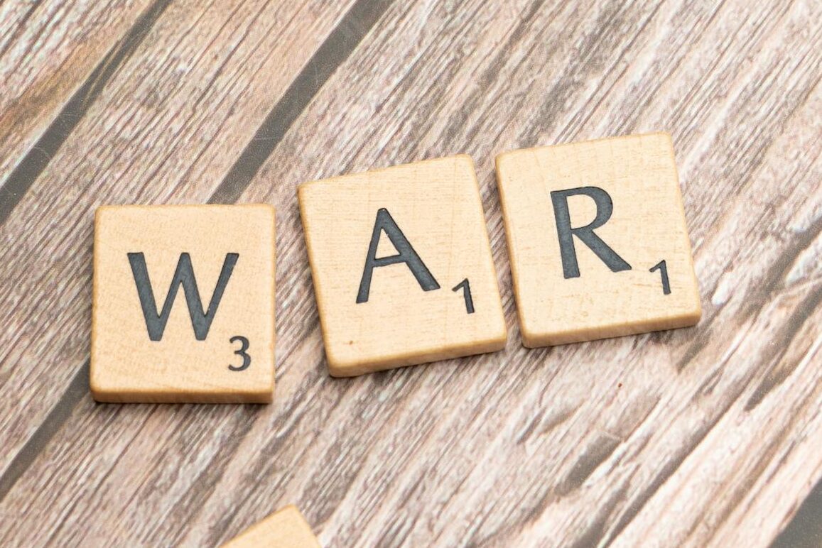 scrabble letters spelling war on a wooden table