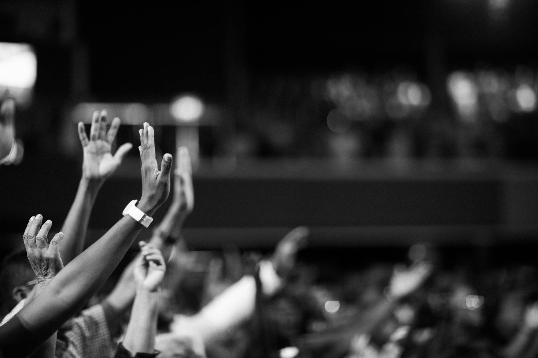 grayscale photography of hands waving and praying