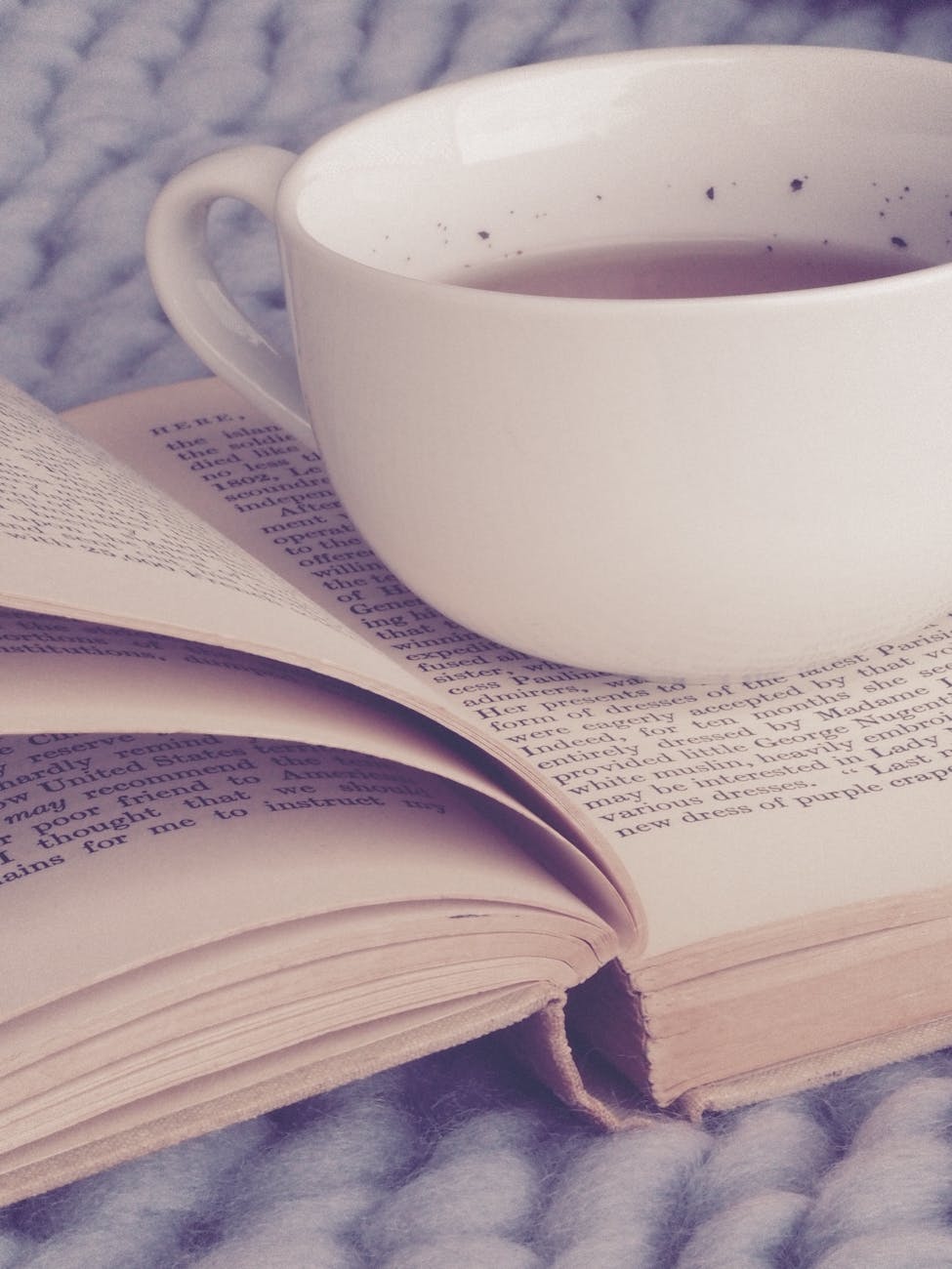 white ceramic cup on top of book