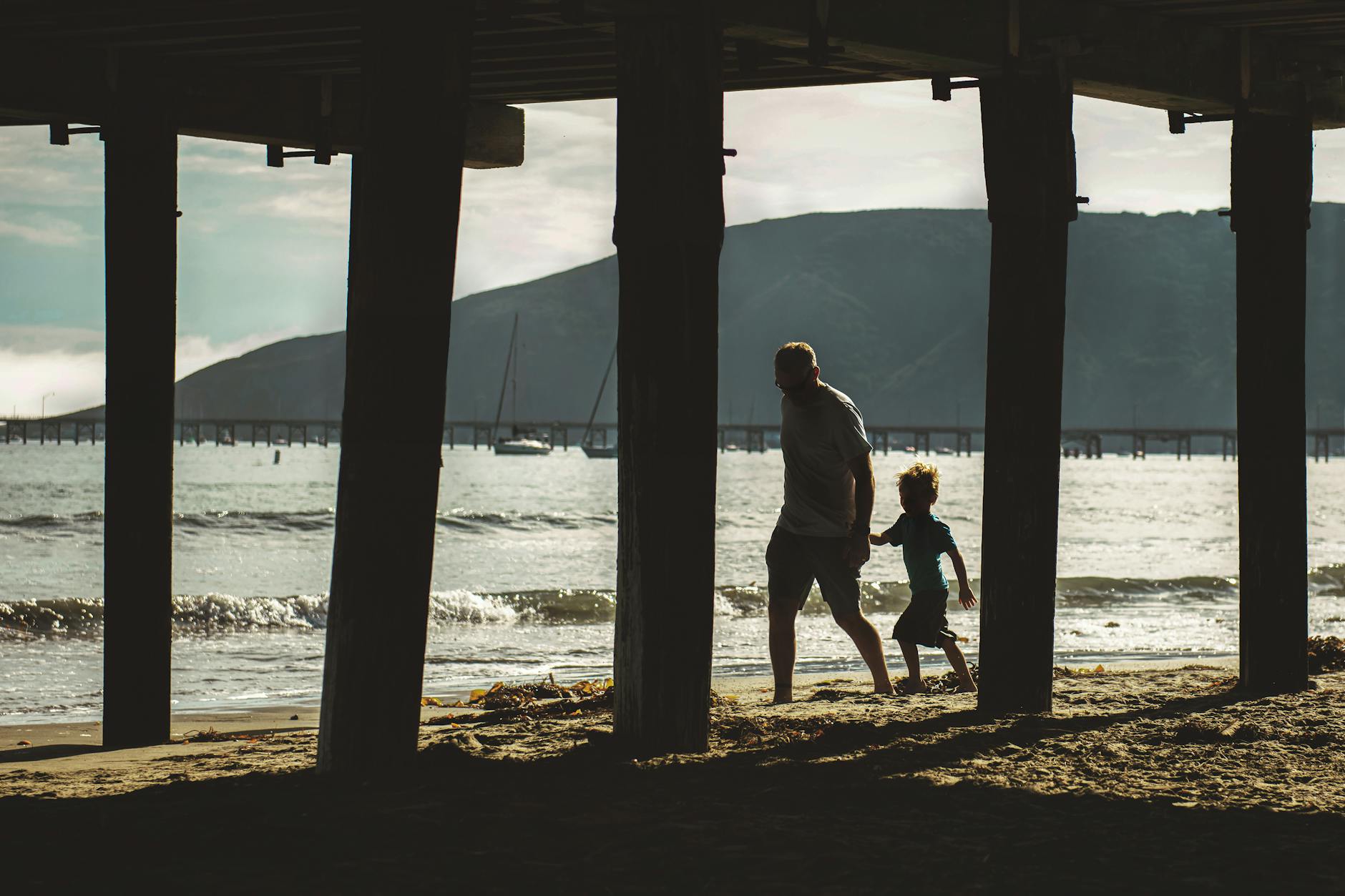 man and child walking on shore beneath the surface
